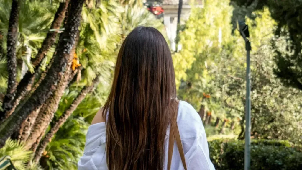 Razgovor bez partnera sa terapeutom pre partnerske terapije: žena sa dugom kosom šeta sama stazom u zelenom parku